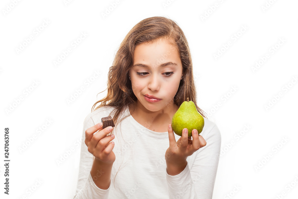 Young girl choosing between fruit and chocolate isolated on white background Young girl choosing between fruit and chocolate isolated on white background