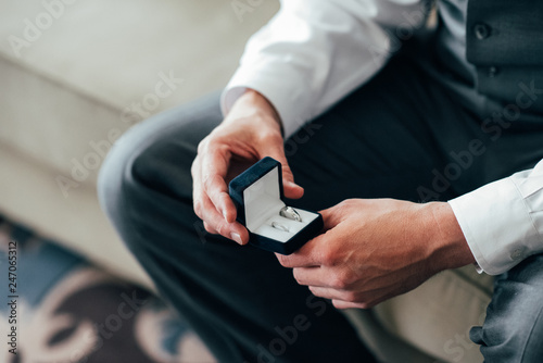 The groom holds the wedding rings in front of the ceremony