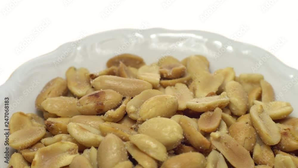 Peanuts. Peeled peanuts fried with salt. Rotation. Snack closeup. Peanuts in a bowl. Selective focus. Isolated on white. Studio shot. Peanuts. Peeled peanuts fried with salt. Rotation. Snack closeup. Peanuts in a bowl. Selective focus. Isolated on white. Studio shot.