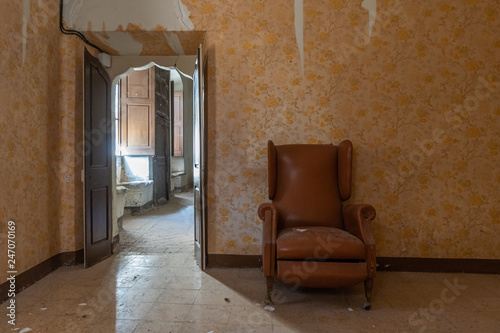 Old armchair in an old abandoned house room