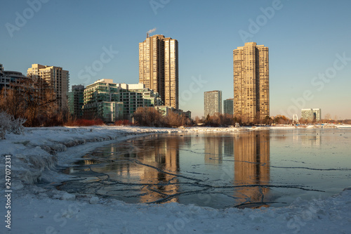 Toronto, CANADA - February 1th, 2019: Panoramic Canadian winter landscape near Toronto, beautiful frozen Ontario lake at sunset. Scenery with winter trees, water and blue sky.