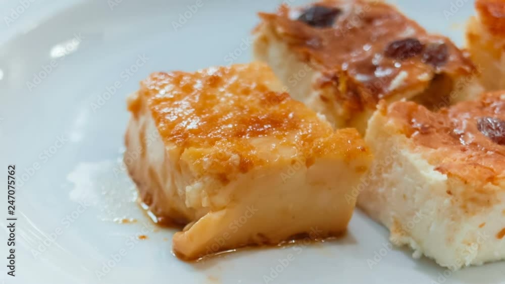 Close-up rack focus shot of delicious slices of cheesecake with raisins and flan pudding at a breakfast table Close-up rack focus shot of delicious slices of cheesecake with raisins and flan pudding at a breakfast table