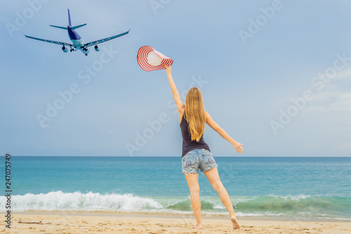 Woman have fun on the beach watching the landing planes. Traveling on an airplane concept