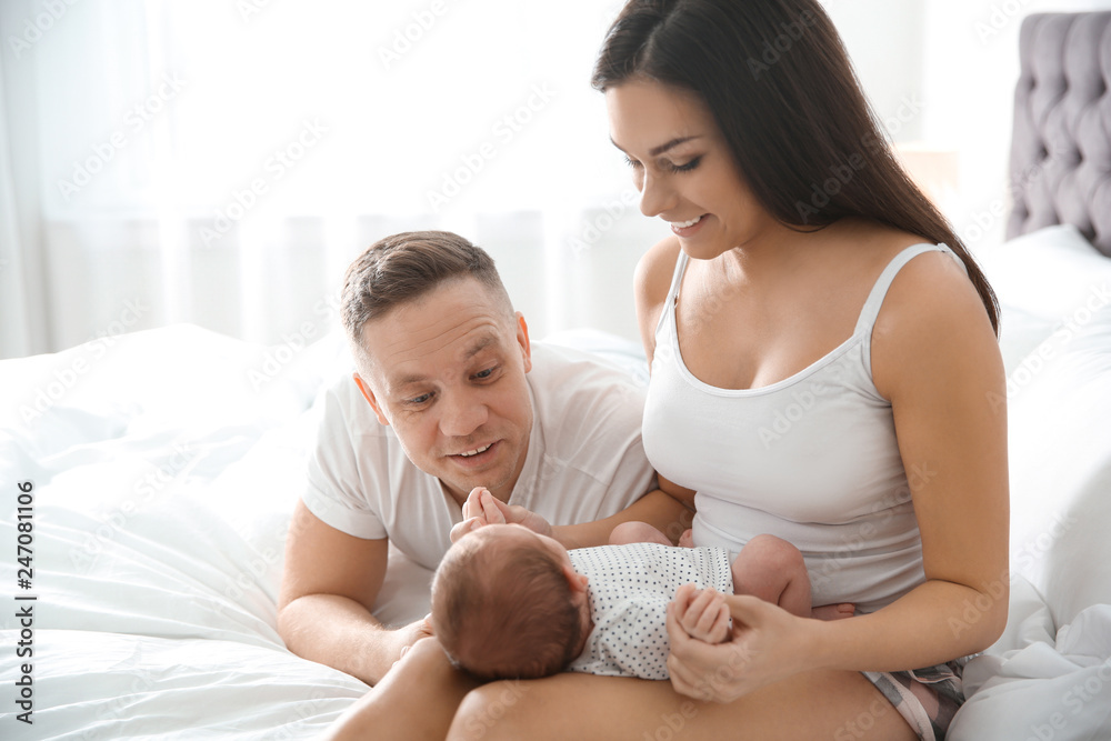 Happy couple with their newborn baby on bed Happy couple with their newborn baby on bed