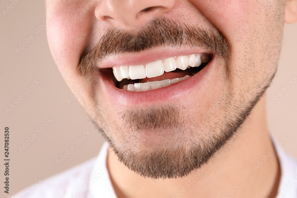 Young man with healthy teeth smiling on color background, closeup Young man with healthy teeth smiling on color background, closeup