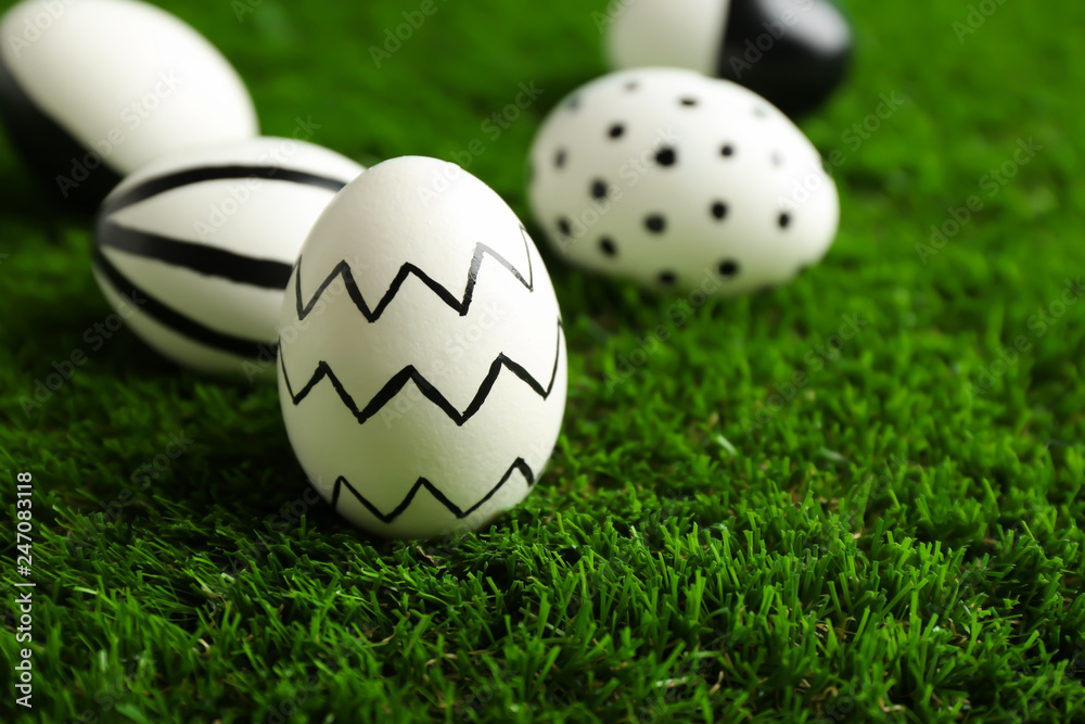 Traditional painted Easter eggs on green lawn, space for text Traditional painted Easter eggs on green lawn, space for text
