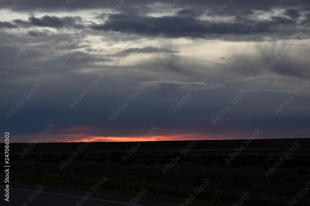 atardecer con cielo tormentoso y sol rojo en patagonia argentina