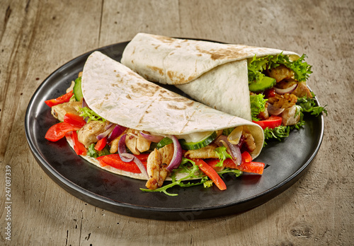 Tortilla wraps with fried chicken meat and vegetables photo