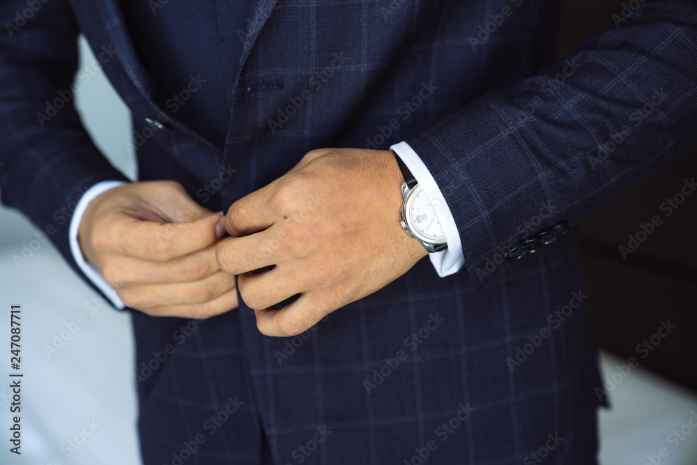 Close-up businessman groom wearing his jacket. Concept of men stylish elegance clothes