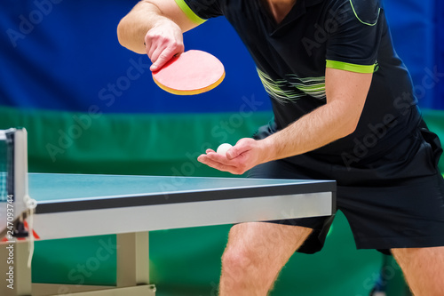 Table tennis player serving, close-up photo