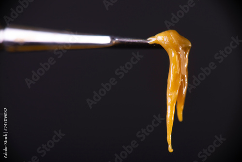 Detail of dab tool with cannabis concentrate aka rosin isolated over black