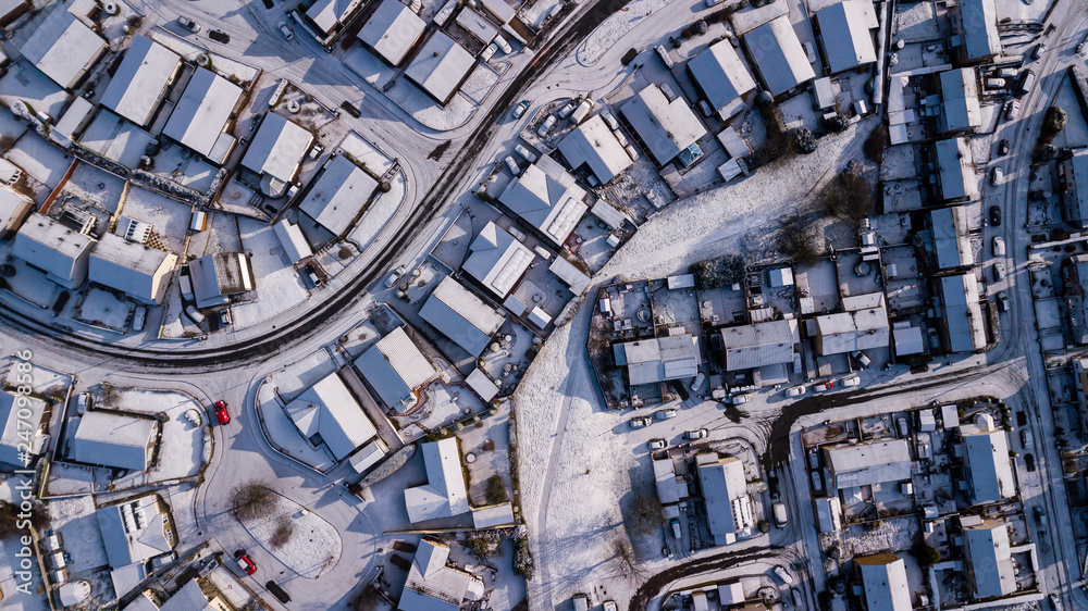 Aerial drone view of winding residential roads surrounded by fresh snowfall