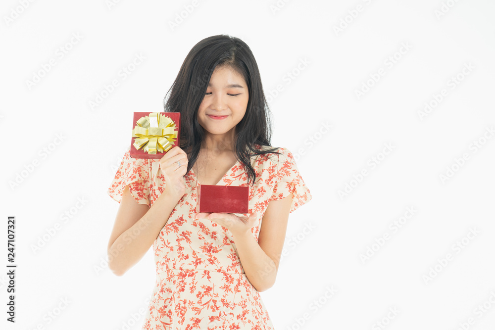 Young woman holding gift box with red bow being excited and surprised holiday present isolated white background Young woman holding gift box with red bow being excited and surprised holiday present isolated white background