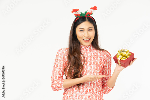 Photo of asian curious woman in red dress rejoicing her birthday or new year gift box. Young woman holding gift box with red bow being excited and surprised holiday present isolated white background