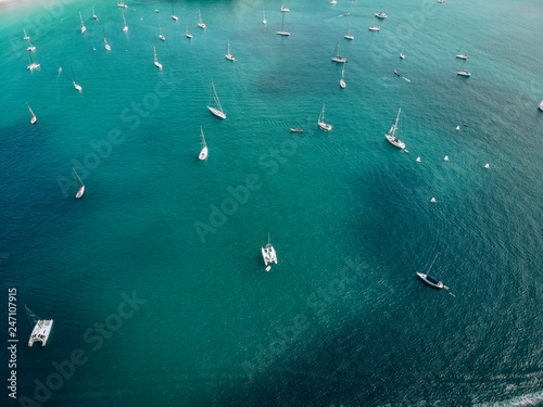 Aerial view of many anchoring yachts in open water. Ocean and sea travel and transportation..