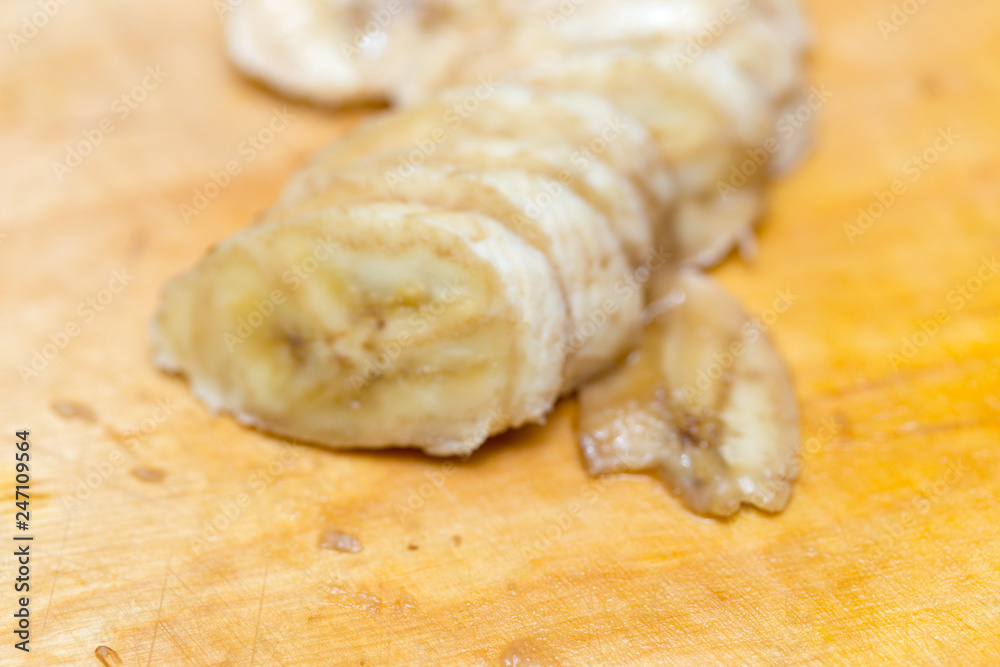 Banana slices on wooden board background