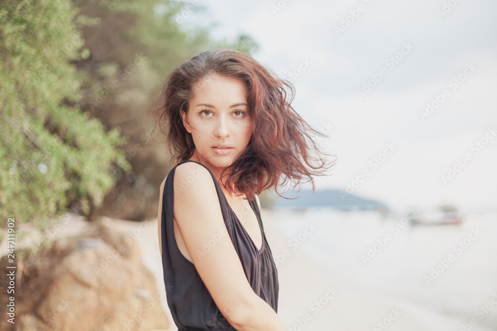 Portrait of a beautiful young woman with dark hair, on the beach, sensual portrait, natural beauty