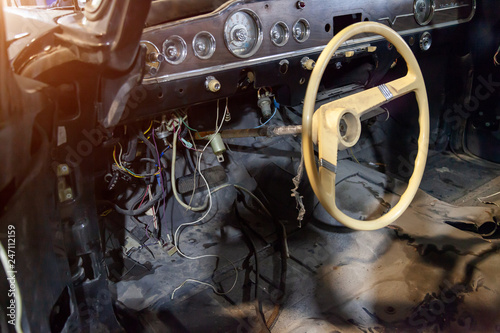 Devices, panel and steering wheel in front of the interior of an old Russian retro car of a representative class, produced in the USSR, disassembled for restoration and restoration