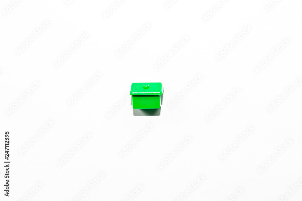 View from the top of the plastic miniature house in green as a part of the monopoly game on a white isolated background View from the top of the plastic miniature house in green as a part of the monopoly game on a white isolated background
