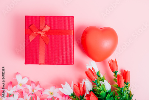 Red heart, flower and gift box on pink background