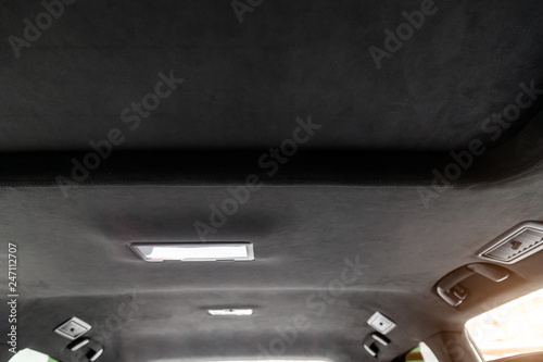 The ceiling of the SUV car pulled by black soft material alkantara in the workshop for tuning and styling the interior photo