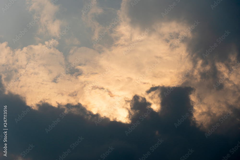 Black clouds, interspersed with golden glowing clouds.