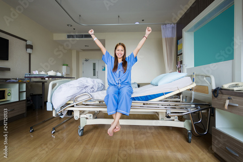 Women patient in blue clothes happy smile with saline solution on hand lying in hospital room at luxury VIP room, Healthcare, medical and Provide vascular nutrients concept.
