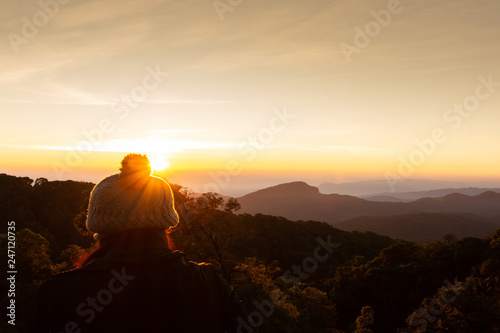 The girl wears a winter coat and beautiful winter sunrise landscape viewpoint at km.41 of Doi Inthanon Chiang Mai Thailand.
