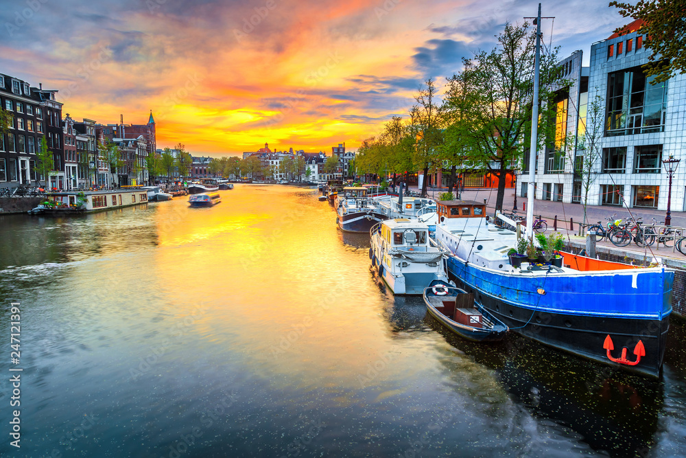 Fototapeta premium City skyline and water canal with houseboats in Amsterdam, Netherlands