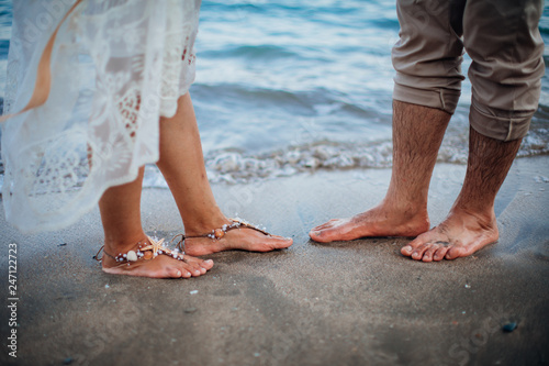 Bride and groom Couple walking on the beach. Man and woman's Feet in the sand. Wedding at the beach