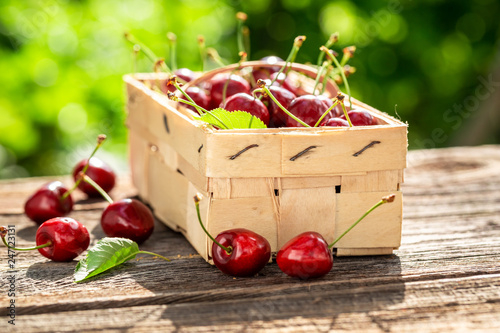 Konstfotografi Tasty and sweet cherries in old wooden punnet