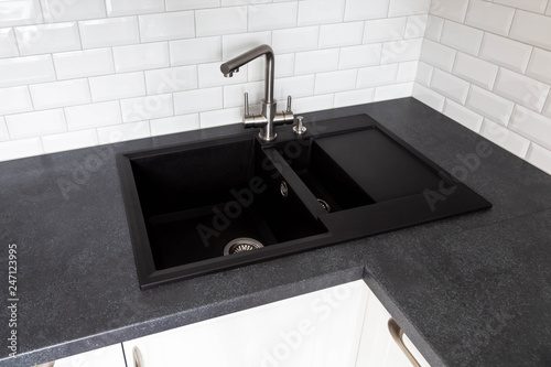 Black granite sink and a mixer mounted on a black countertop