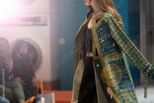 Fotografie Fashion dress Model walk back on dark Runway Fashion Show catwalk with lighting