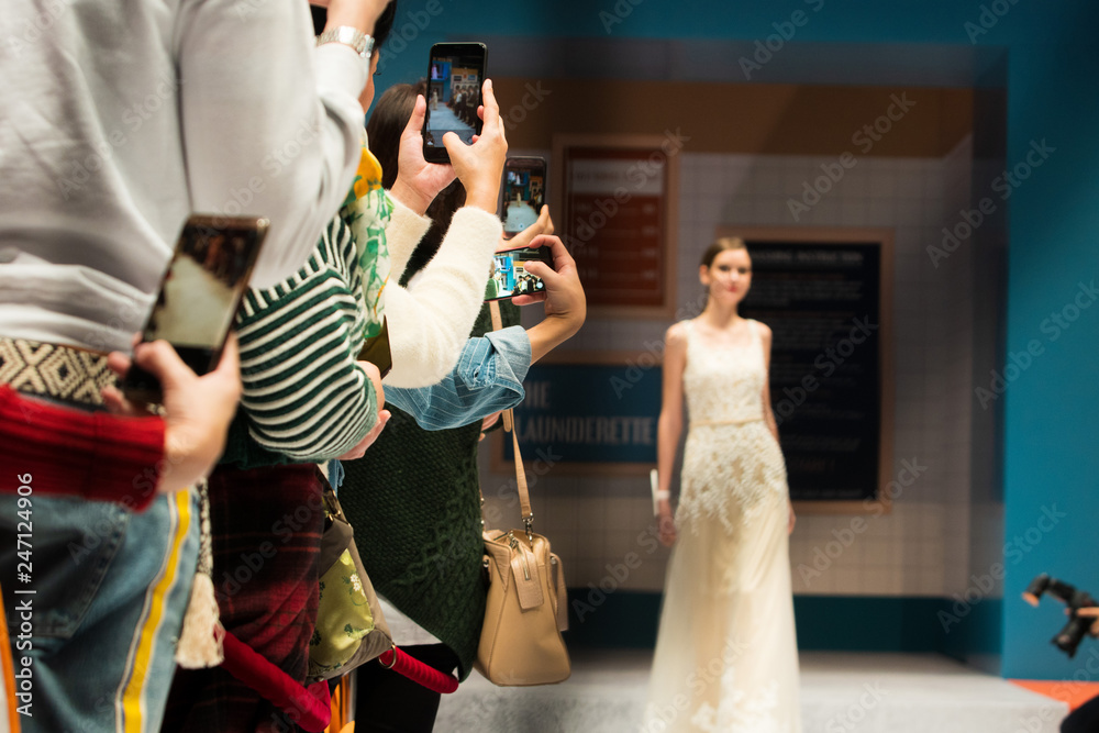 Fashion dress Model walk back on dark Runway Fashion Show catwalk along way finale, background stage ramp, copy space for text logo, audiences use smartphone mobile phone take photo bad manner way - obrazy, fototapety, plakaty 