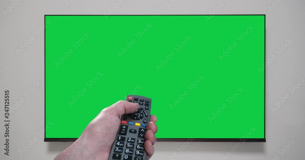 4K - Hand with remote control changes channels tv. Green screen. Chroma key