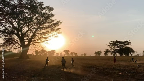 African kids playing football in the sunset on a field tc01