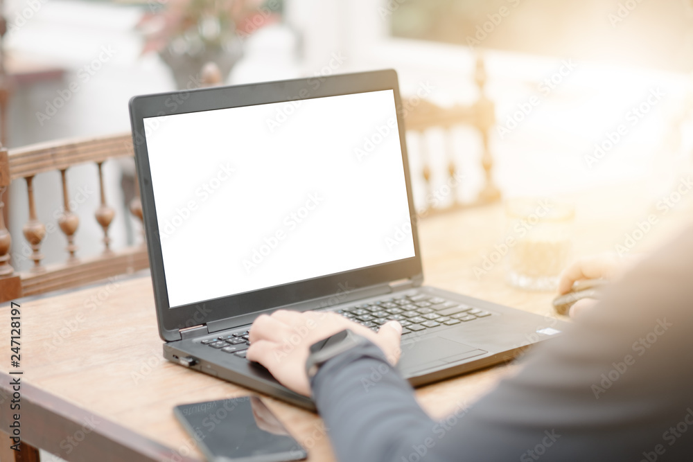 close-up woman hand typing keyboard computer showing white screen in coffee shop