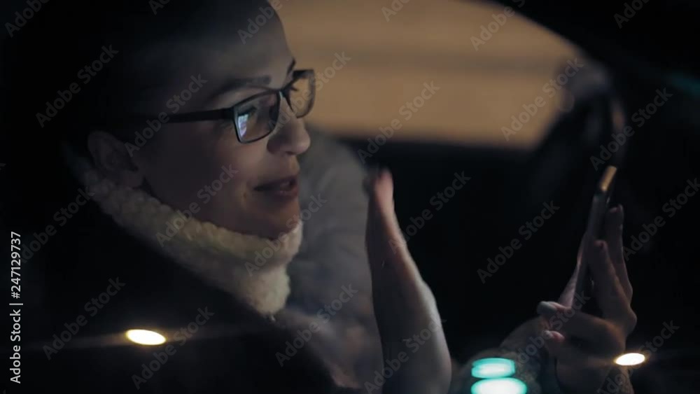 lifestyle a woman has online video chat with family , sitting in the car on a winter evening lifestyle a woman has online video chat with family , sitting in the car on a winter evening