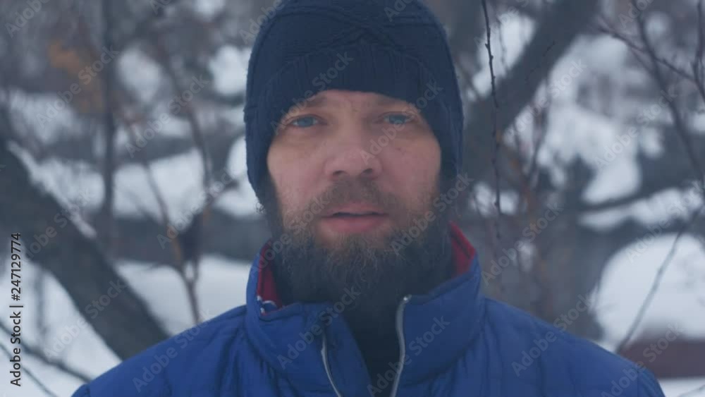 Caucasian man with a beard in a sports cap, winter portrait Caucasian man with a beard in a sports cap, winter portrait