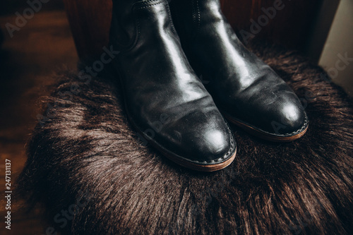 Fotografie men's black leather shoes stand on the bearskin