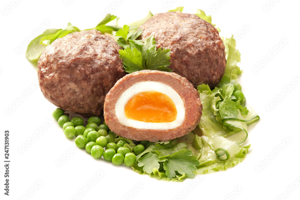 Fototapeta premium Egg wrapped in minced meat with vegetable garnish