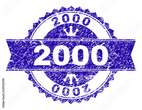 2000 rosette stamp watermark with grunge texture. Designed with round rosette, ribbon and small crowns. Blue vector rubber print of 2000 caption with grunge texture.