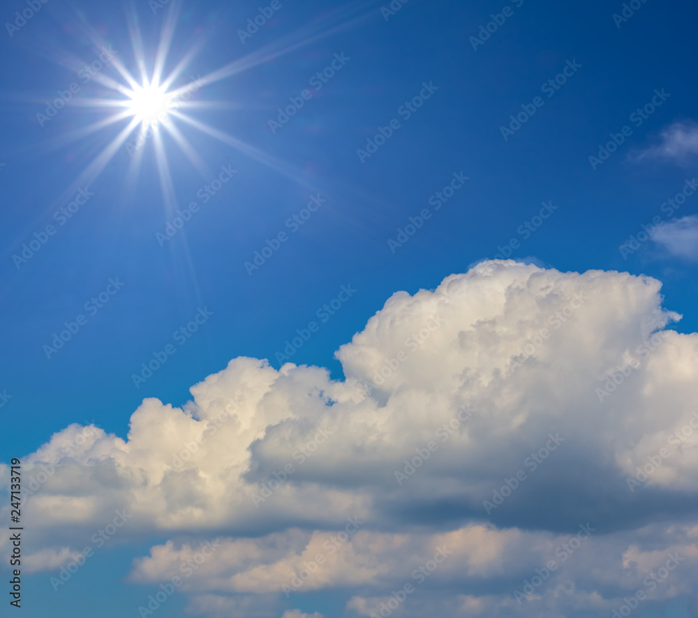 nature background, sparkle sun on a blue sky above a cumulus clouds
