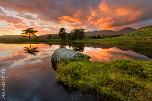 Fiery Dramatic Sunset Over Kelly Hall Tarn In The English Lake District. photo