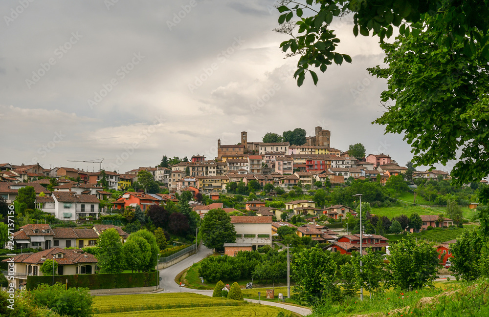 Scenic view of a village on a hill with a medieval castle on the top in a cloudy day in springtime, Roddi d'Alba, Langhe, Piedmont, Italy