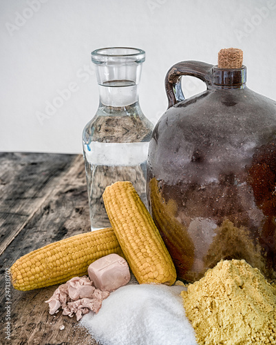 Картината върху платно moonshine demi jug and ingredients on rustic wooden table
