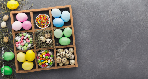 Colored Easter and quail eggs set on black table