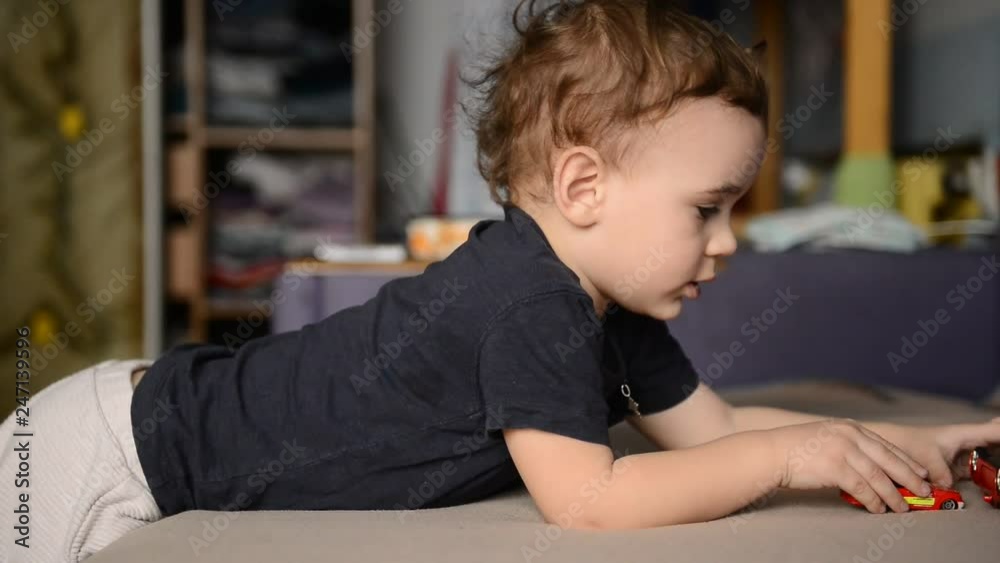 little boy playing with toy car in the children's room