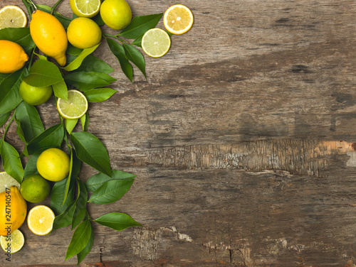 fresh, juicy lemons and limes lie on an old wooden background