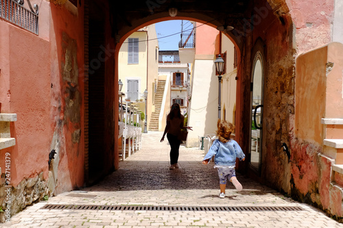 A little girl run towards her mom in the picturesque Italian village. San Felice Circeo, Lazio, Italy